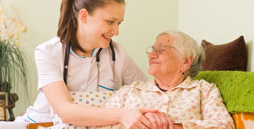 Older lady being visited by a nurse at home